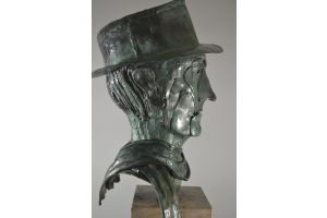 Bronze but of a man with hat and scarf.